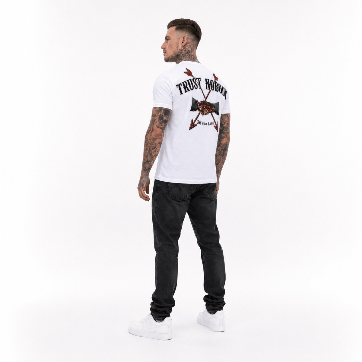 Trust nobody embroidery T-shirt in white worn by model, angled from behind with the embroidered back print