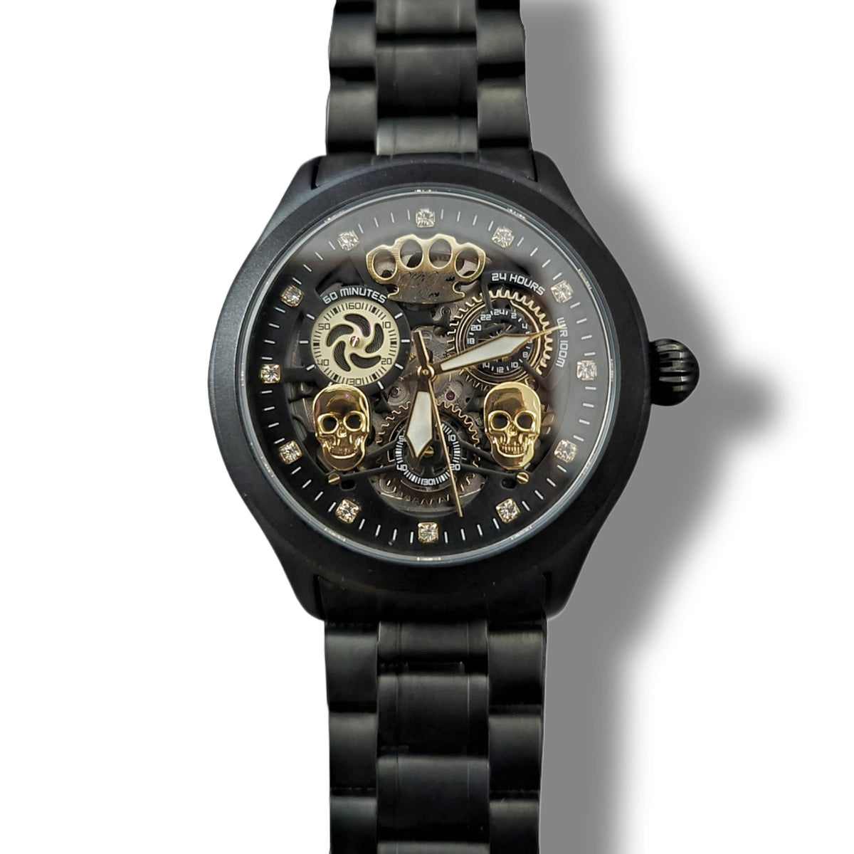 Przód matowego czarnego zegarka Double skull z dwiema złotymi czaszkami i odsłoniętym mechanizmem