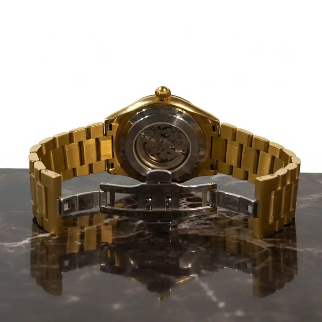 Rückseite der goldenen MVL Double skull Uhr mit offenem Gehäuse und Faltschließe auf Marmor