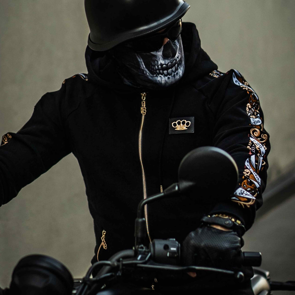 Modelo con máscara de calavera y casco con la sudadera Savage ornate negra en una moto