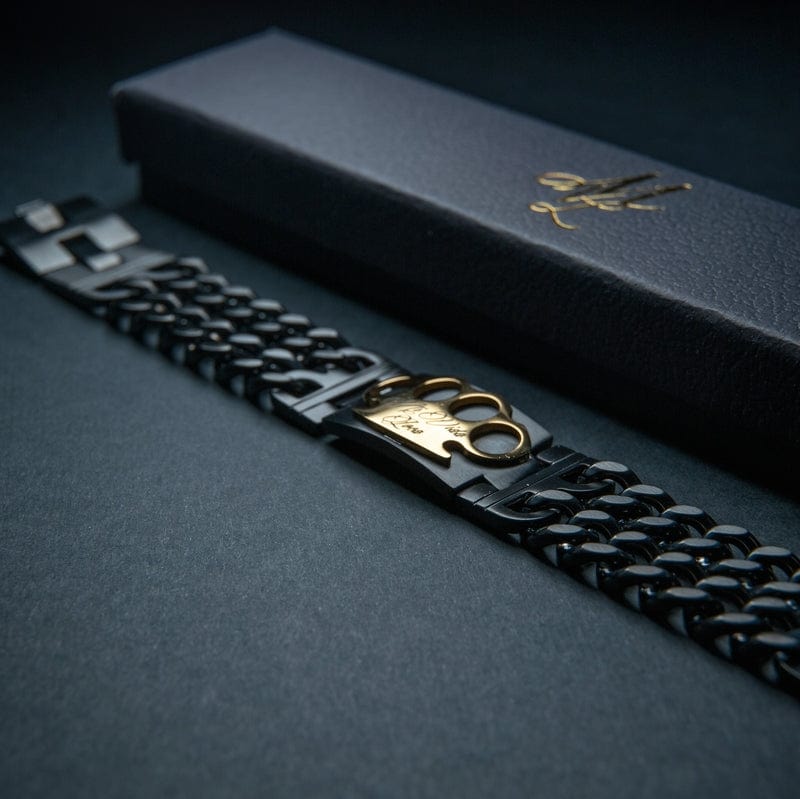 Mi Vida Loca Bracelet czarno-złota, czarna bransoletka ogniwowa ze złotym logo MVL obok czarnego pudełka