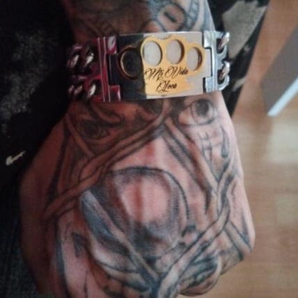 Primo piano del bracciale MVL con logo MVL dorato e incisione Mi Vida Loca al polso