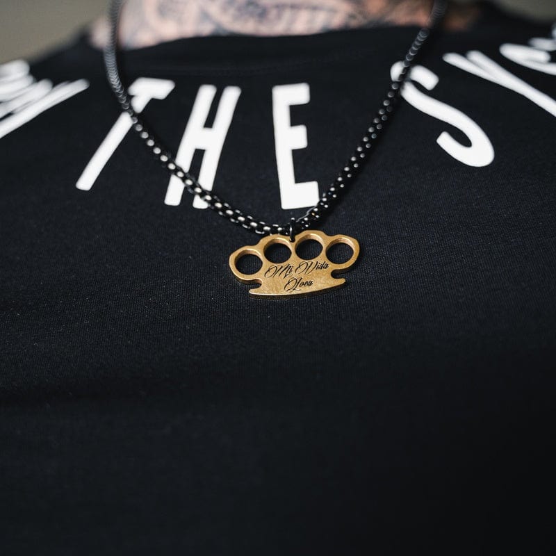 Schwarze MVL Logo chain mit goldenem MVL-Logo-Anhänger, getragen auf einem schwarzen T-Shirt