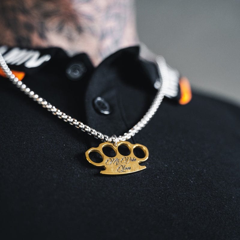 MVL Logo Kette silber/gold über einem schwarzen Shirt getragen, Nahaufnahme des Anhängers