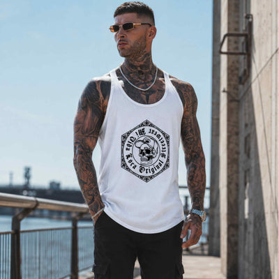 Tätowiertes Model mit Sonnenbrille trägt das weiße MVL Original streetwear Tanktop am Wasser