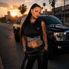 Top femme Mi Vida Loca Signature noir porté par une mannequin avec pantalon en cuir près d'un pick-up noir